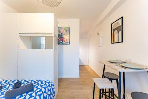 um pequeno apartamento com sala de jantar e cozinha em Le charmant Jules Julien parking privé em Toulouse