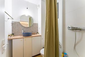 um banheiro com uma pia e um espelho em Le charmant Jules Julien parking privé em Toulouse