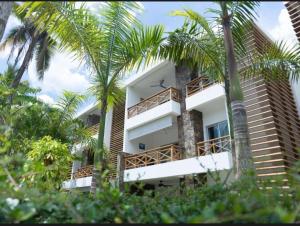 ein Gebäude mit Palmen davor in der Unterkunft Paradise Found 3Bedroom Apartment with Pool in Las Terrenas