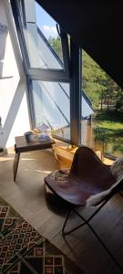 a chair sitting in a room with a large window at Divčibarski kutak in Divčibare