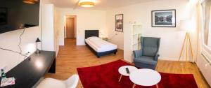 a living room with a bed and a chair at Hotel Quellenhof - Self-Check-in in Bad Urach