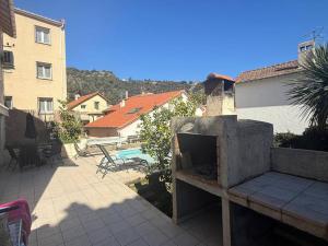 阿梅利莱班帕拉勒达F2 Climatisé Proche Cures, Amélie-les-Bains - FR-1-703-208的后院设有室外壁炉和游泳池