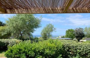 a view of a garden with trees and bushes at Chalet 35m2 - Armen in Plouhinec +7 photos