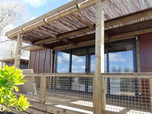 a wooden deck with a pergola on a house at Chalet 35m2 - Armen in Plouhinec