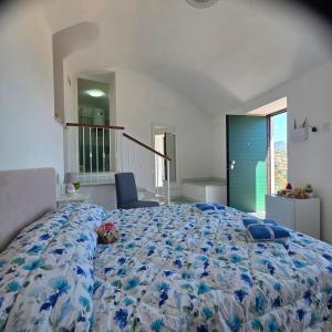 a bedroom with a large bed with a blue comforter at JANET HOUSE in Amalfi