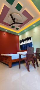 a room with a bed and two chairs and a ceiling at Hampi Icon Palace in New Hampi