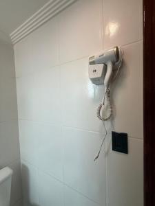ein Telefon, das an einer Wand im Bad hängt in der Unterkunft Apartamento no Centro de Sorocaba com vaga de garagem in Sorocaba