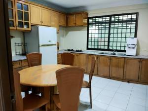 a kitchen with a wooden table and a refrigerator at HANNI HomeStay in Sibu
