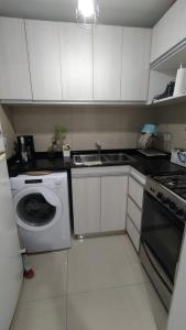 una cocina con lavadora y fregadero en Centrico loft, en Puerto Madryn