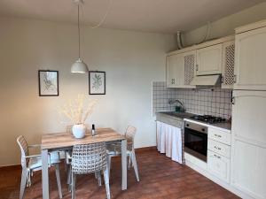 Casetta Valmora في Valpiana: مطبخ مع طاولة خشبية مع كراسي وطاولة طعام