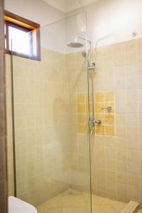 a bathroom with a shower with a glass door at Salt Garden Inn in Dar es Salaam