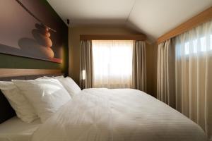 um quarto com uma cama branca e uma janela em Les Pantoufles dans le Pré em Eppeldorf