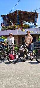 阿勒皮Peace and love beach stay的两个男人坐在长椅上，旁边是他们的自行车。