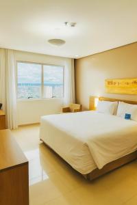 Un dormitorio con una cama grande y una ventana grande. en Blue Tree Premium Manaus, en Manaus