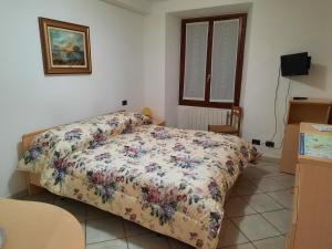 a bedroom with a bed with a floral comforter at Affittacamere Ossola in Domodossola