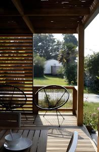 twee stoelen op een veranda met uitzicht op een tuin bij Chalet 35m2 - Molène in Plouhinec