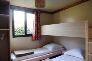 twee stapelbedden in een kamer met een raam bij Chalet 35m2 - Molène in Plouhinec
