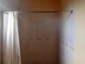 a shower with a white shower curtain in a bathroom at WilN Apartments in Francistown +14 photos
