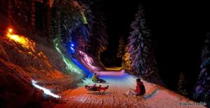 a group of people sitting in the snow at night at Hirzhof SO Bike&Ski Ridehaus Ski In Ski Out in Auberg +80 photos