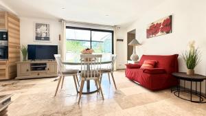 een woonkamer met een rode bank en een tafel bij Le Titibu, Gîte et Spa entre Ardèche et Provence, Clim, BBQ, Netflix, classé 5 étoiles in Saint-Paulet-de-Caisson