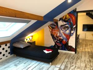 a bedroom with a large painting on the wall at La Tranquilitude in Ceyzérieu