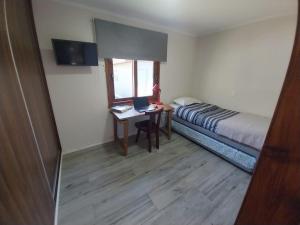 a small room with a bed and a desk with a laptop at Refugio de montaña in El Manzano