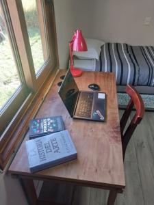 a wooden table with a laptop computer and a keyboard at Refugio de montaña in El Manzano