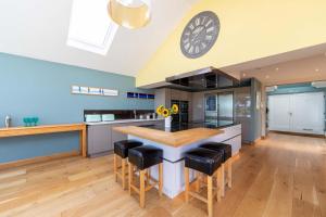 a kitchen with a table and a clock on the ceiling at Lakeside in Compton Martin
