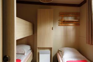 two bunk beds in a small room with twounks at Chalet 25m2 - La Vieille in Plouhinec