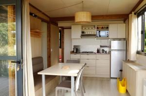 a small kitchen with a table and a refrigerator at Chalet 25m2 - La Vieille in Plouhinec