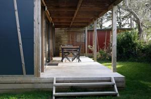 a wooden porch with a table and a bench at Chalet 30m2 - Eckmühl in Plouhinec