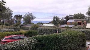 a red car parked in front of a house at Mobil-home Les volets jaunes in Plouhinec +3 photos