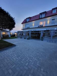 a large building with a patio in front of it at POKOJE APARTAMENTY ANASTAZJA in Grzybowo +65 photos