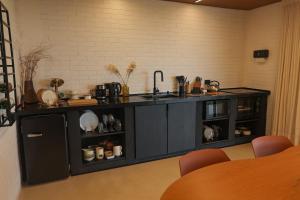 a kitchen with a black counter and a sink at Casa de Campo - Valle Paixão in Campo Largo