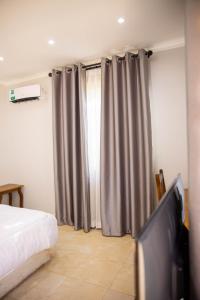 a bedroom with a bed and a flat screen tv at Salt Garden Inn in Dar es Salaam +32 photos