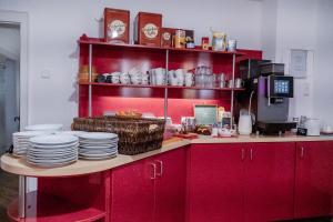 a kitchen with red cabinets and plates on a table at Stadt-gut-Hotel Rheinischer Hof in Essen