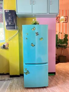 Un refrigerador azul con mariposas en una cocina. en The Peach Villa, en Bombay