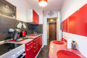 una piccola cucina con armadi rossi e uno sgabello rosso di beau T1 30 résidence sécurisée proche centre ville parking privé wifi a La Celle-sous-Gouzon Altre 28 foto