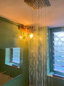 Un baño con ducha con agua colgando del techo. en The Peach Villa, en Bombay