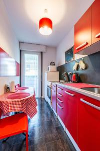 una cucina con armadi rossi e un tavolo con una tovaglia rossa di beau T1 30 résidence sécurisée proche centre ville parking privé wifi a La Celle-sous-Gouzon