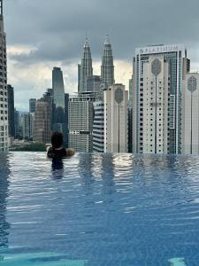 una persona en una piscina con un perfil urbano en KLCC View City Center At Majestic residence, en Kuala Lumpur 37 fotos más