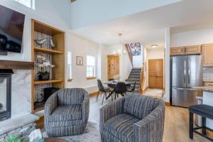 a living room with two chairs and a table and a refrigerator at 3 BR Fraser Apartment in Fraser
