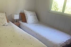 twee bedden naast elkaar in een kamer bij Chalet Bungalow 2 Chambres 56 in LʼEstréchure +18 foto's