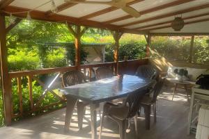 een terras met een tafel en stoelen op een dek bij Chalet Bungalow 2 Chambres 56 in LʼEstréchure