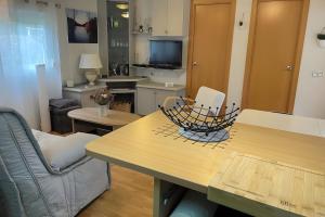 een woonkamer met een tafel en stoelen en een keuken bij Chalet Bungalow 2 Chambres 56 in LʼEstréchure