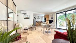 een woonkamer met een rode bank en een tafel bij Le Titibu, Gîte et Spa entre Ardèche et Provence, Clim, BBQ, Netflix, classé 5 étoiles in Saint-Paulet-de-Caisson