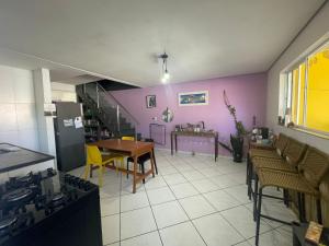 a kitchen with purple walls and a table and chairs at Casa de Praia- Suíte São Lourenço in Bertioga