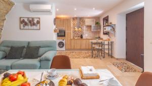 a living room with a couch and a table with food at Cueva El Arrabal Setenil by Ruralidays in Setenil