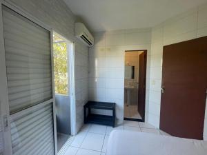 a bathroom with a toilet and a window and a door at Casa de Praia- Suíte São Lourenço in Bertioga