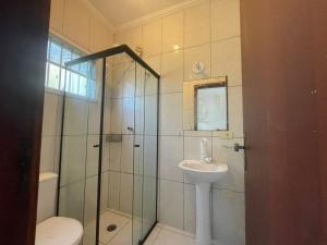 a bathroom with a shower and a sink and a toilet at Casa de Praia- Suíte São Lourenço in Bertioga